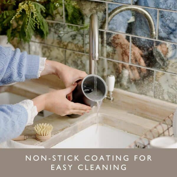 Person rinsing a Dualit handheld milk frother under a tap, highlighting its non-stick coating.